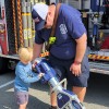 a firefighter shows a child fire equipment