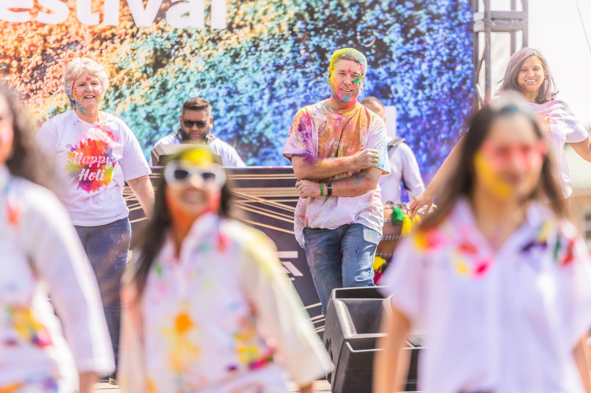 council members and participants showing colors at the Holi festival